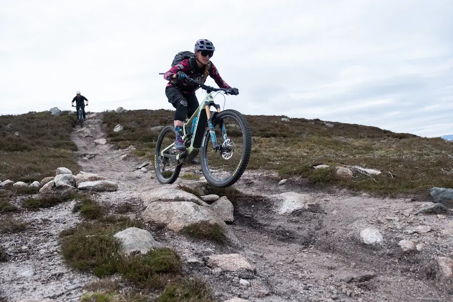 Female e-mountain biker in Scotland descending rocky trails