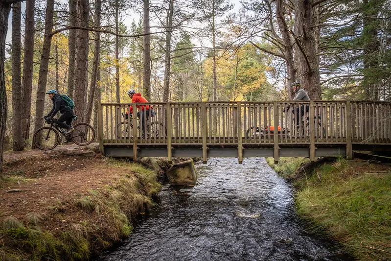 Cyclists riding over a bridge in the Cairngorms National Park