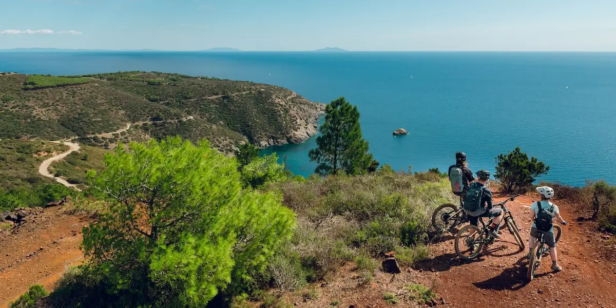 Mountain bikers looking out to sea on an international E-MTB tour Tuscany