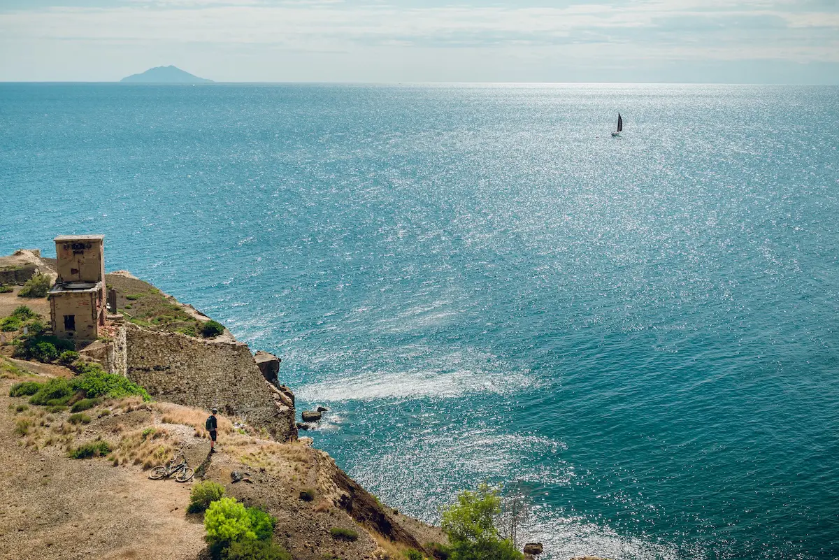 Mountain biker looking out to sea from the Island of Elba, E-MTB tours Europe