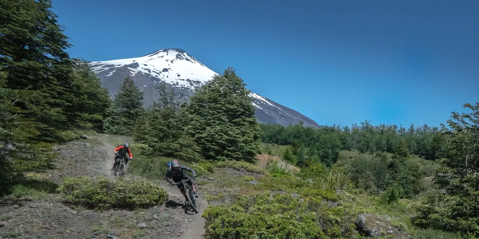 Mountain bikers riding in front of a volcano in Chile