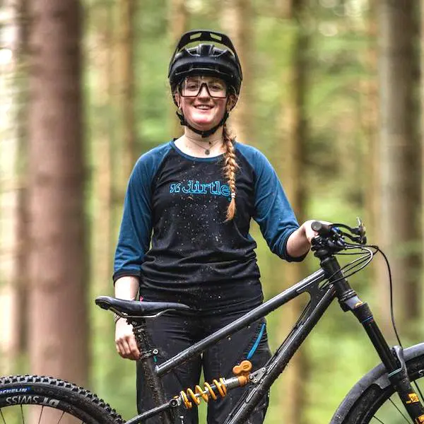 Local guide Hâf with her mountain bike standing in the forest.