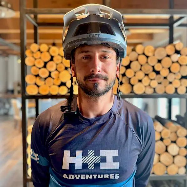 A portrait of E-MTB Tuscany guide Danilo wearing his H+I Adventures jersey and wearing his helmet