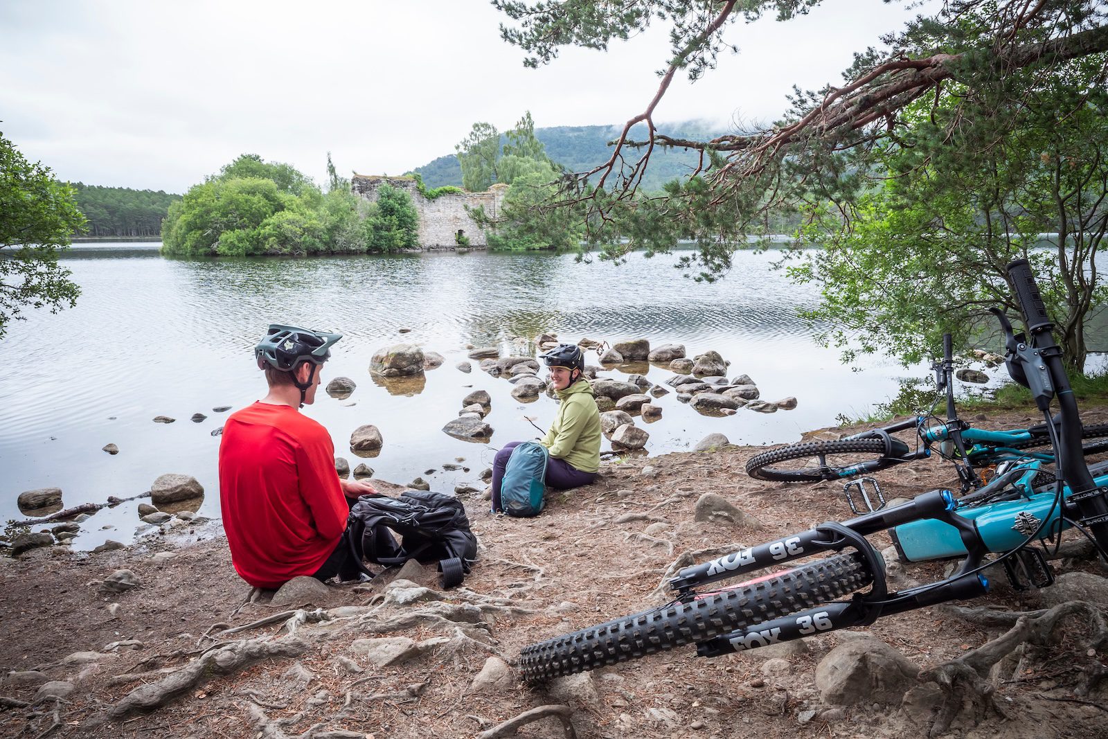 Mountain bikers stopping for lunch at the edge of a loch in the Scottish Highlands