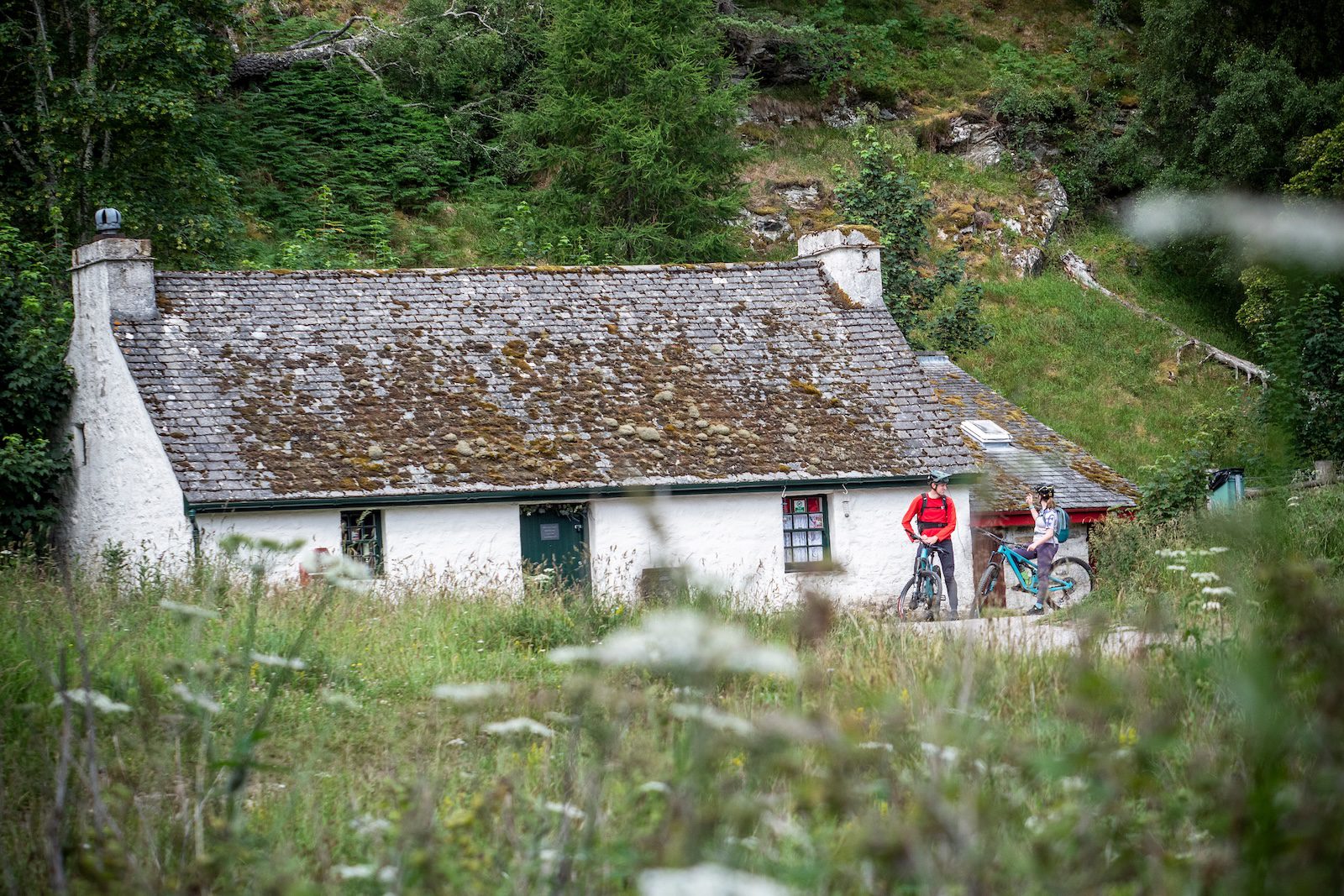Mountain bikers outside an old bothy in the Cairngorms National Park, Scotland
