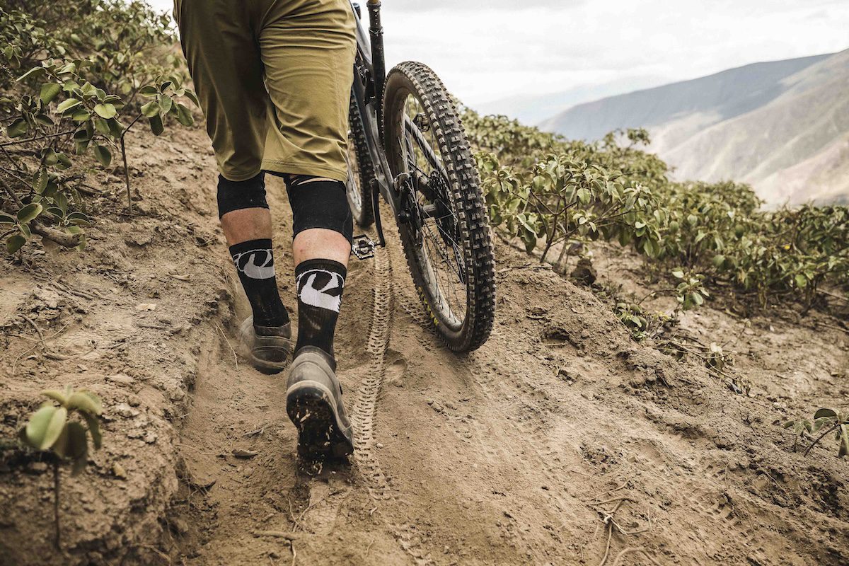 Mountain biker walking on sand in Ecuador