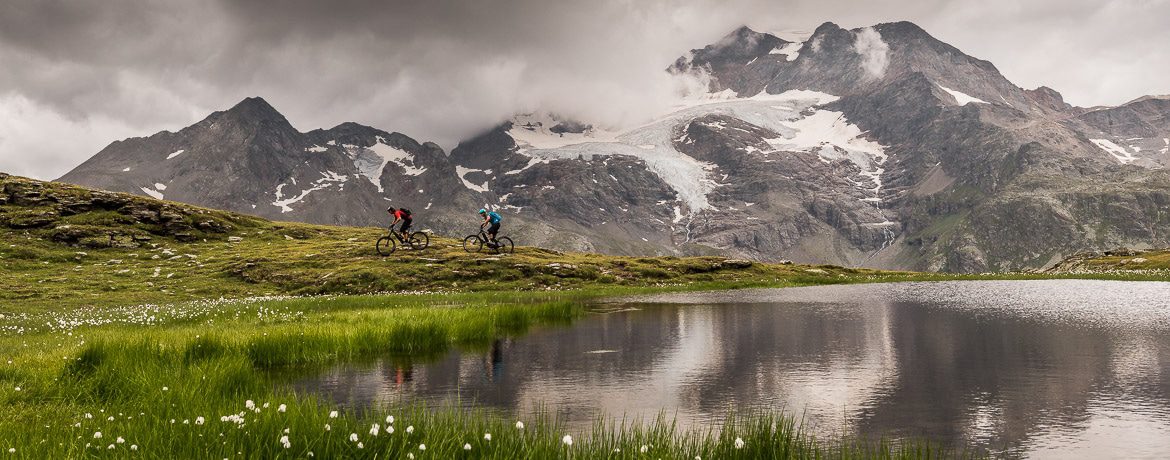 Riding alongside an alpine lake on a E-MTB Tour In Switzerland in photos