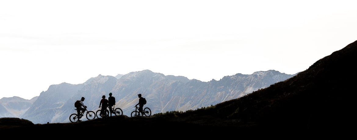 Mountain bikers stopping to catch their breath in the mountains above Poschiavo during our Switzerland mountain biking tour