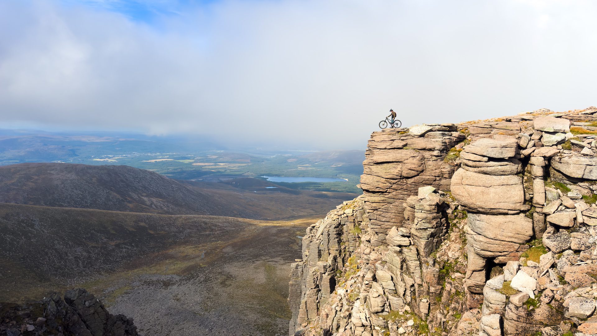 Sandy standing with his bike on the edge of the Cairngorm plateaux.