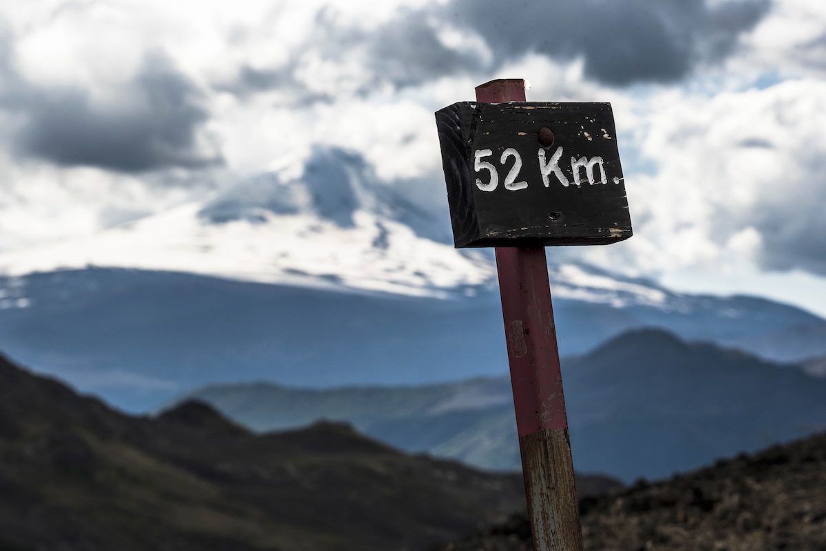 Sign in Chile with volcano in background, complete travel guide to mountain biking in Chile